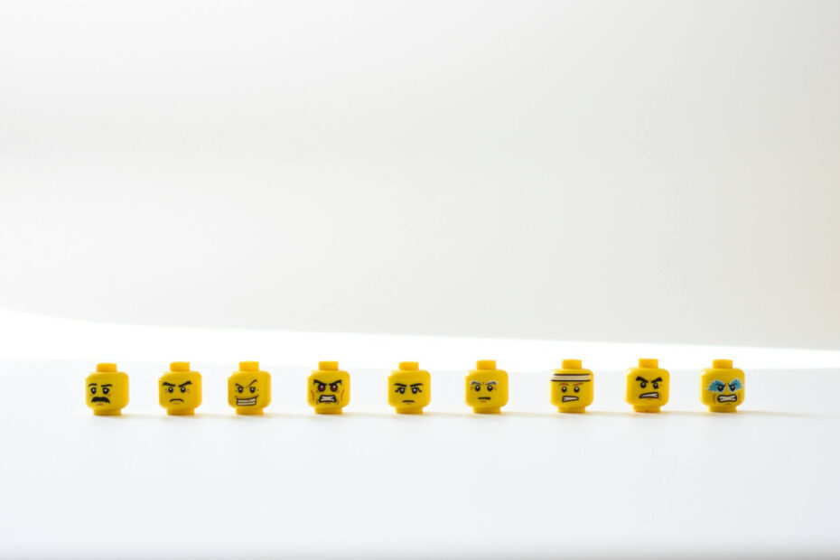 Row of yellow LEGO heads displaying different intense facial expressions, symbolizing the variety of emotions involved in learning anger management tricks.