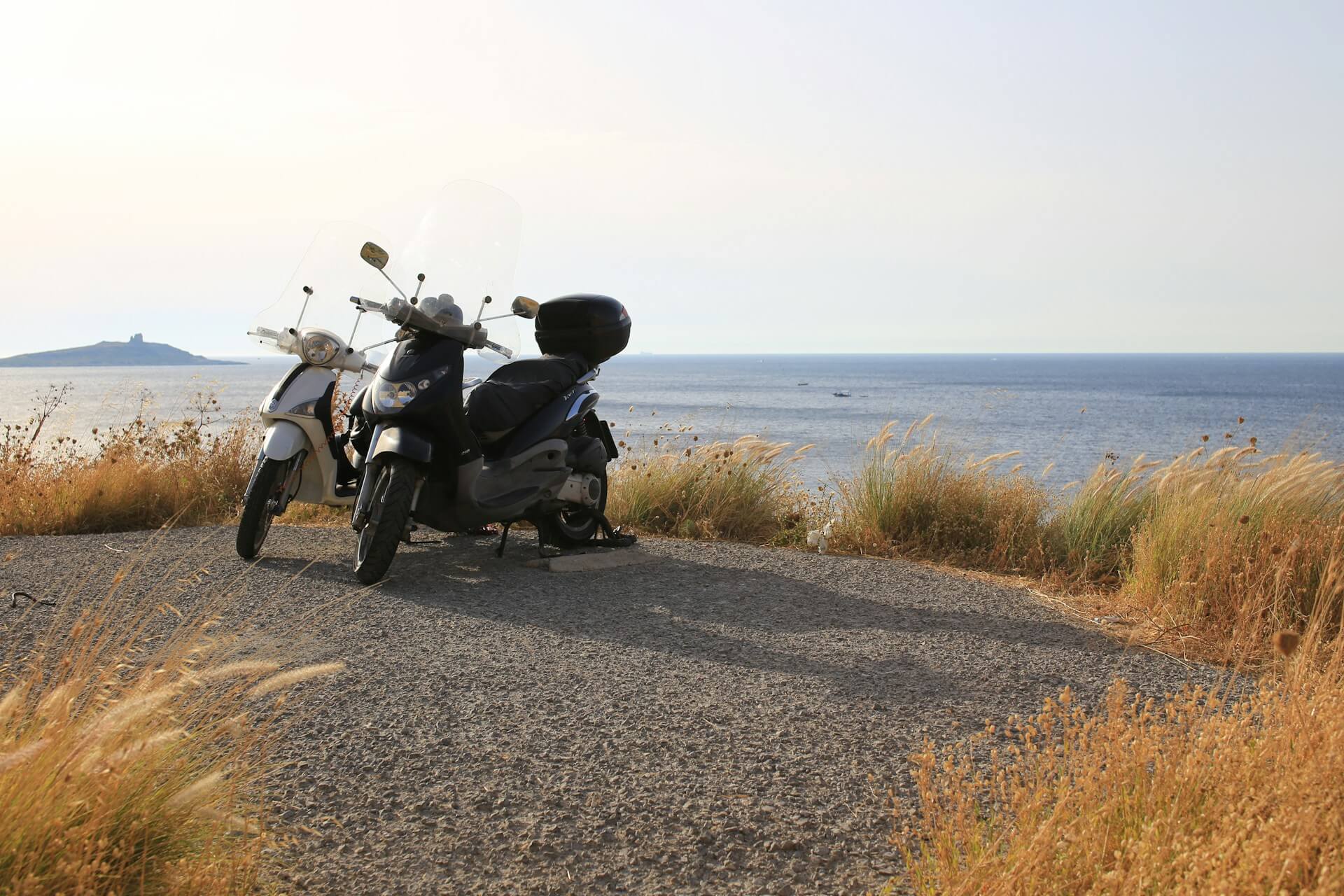Two parked scooters overlooking the sea, symbolizing companionship, shared journeys, and the idea of healthy relationships.