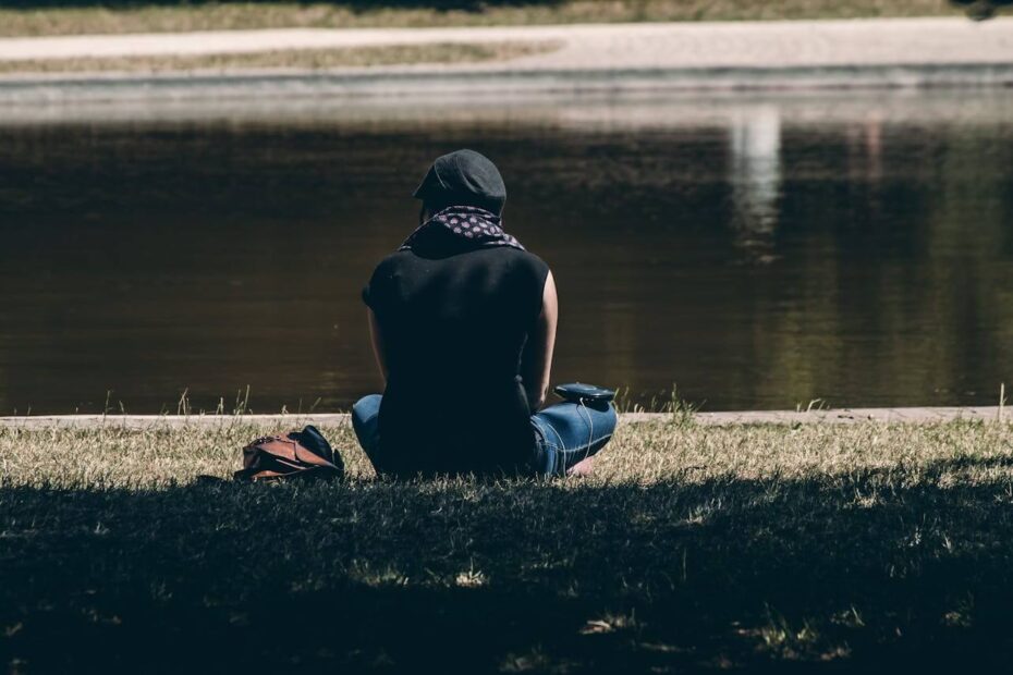 Person sitting alone by the water reflecting calmly, representing not reacting to toxic people and choosing inner peace.