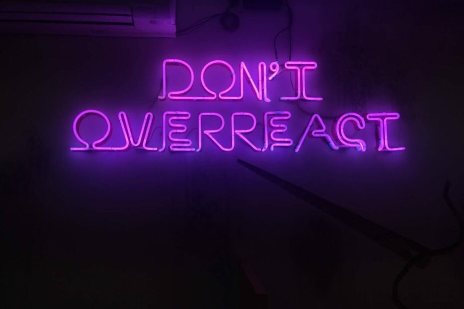 Neon purple sign reading don’t overreact symbolizing emotional control and overcoming overreacting